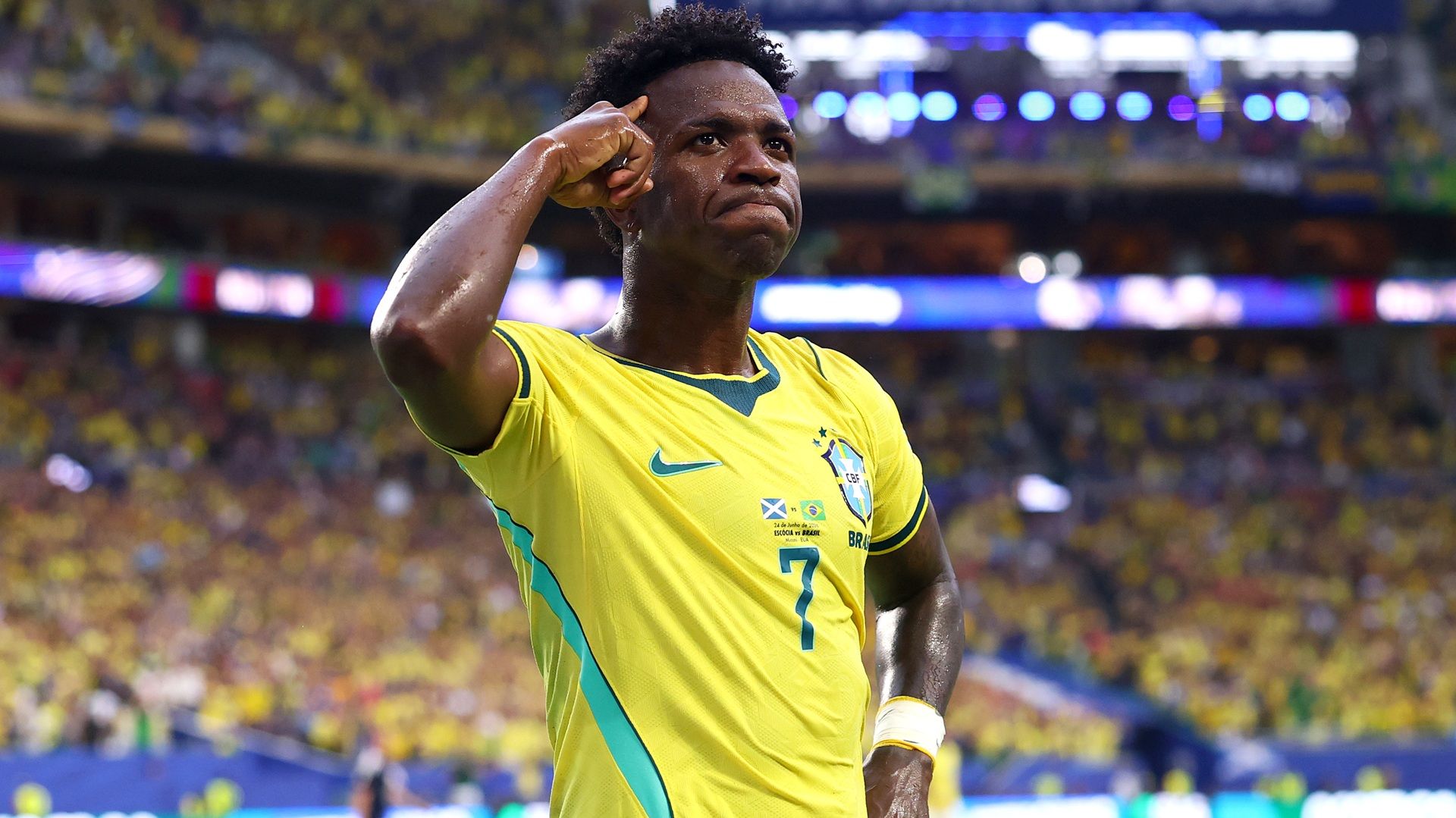 Vinicius Junior #7 of Brazil, wearing yellow shirt, celebrates scoring his team's second goal during the FIFA World Cup 2026, saluting the crowd in a packed stadium