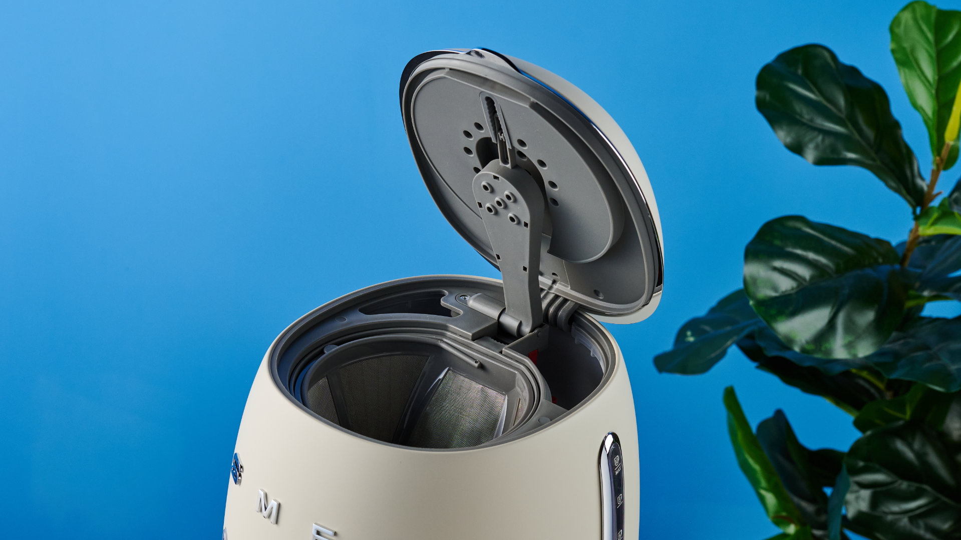 מכונת הקפה רטרו smeg שצולמה על רקע המדריך הכחול של טום