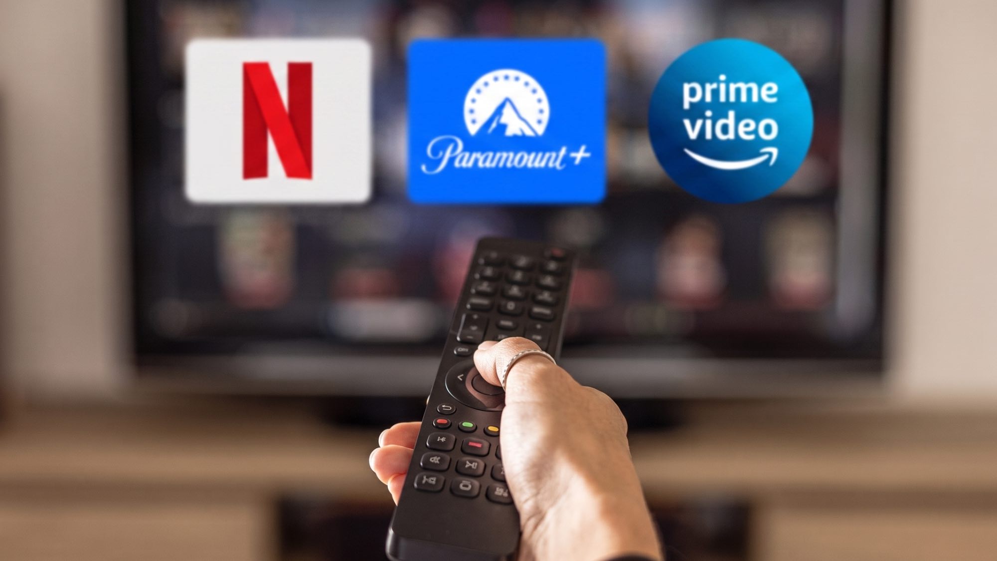לוגו של Netflix, Paramount Plus ו-Prime Video בטלוויזיה עם שלט