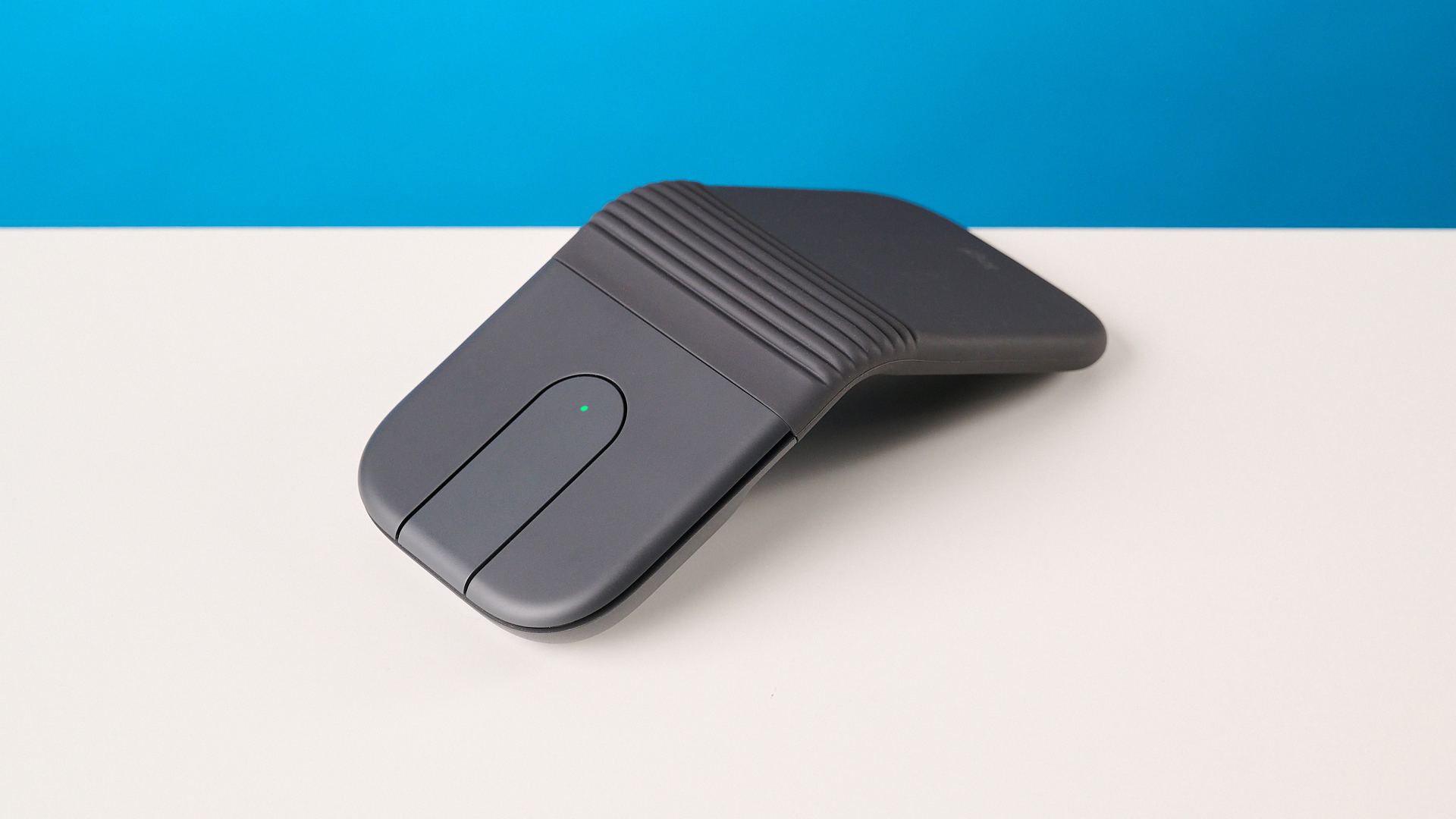 עכבר Logitech Mobi Fold בגרפיט מצולם מול רקע כחול