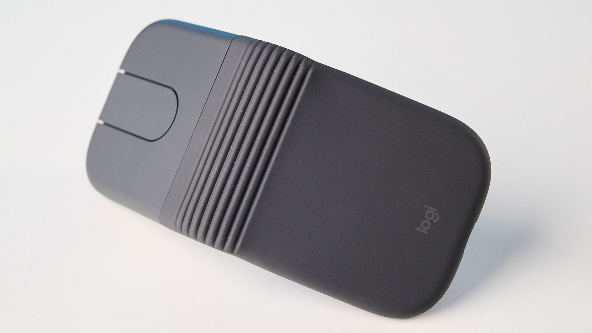 עכבר Logitech Mobi Fold בגרפיט מצולם מול רקע כחול