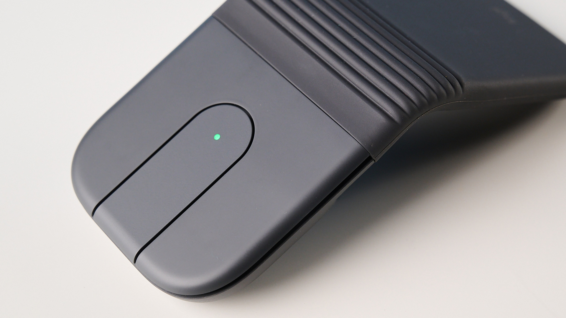עכבר Logitech Mobi Fold בגרפיט מצולם מול רקע כחול