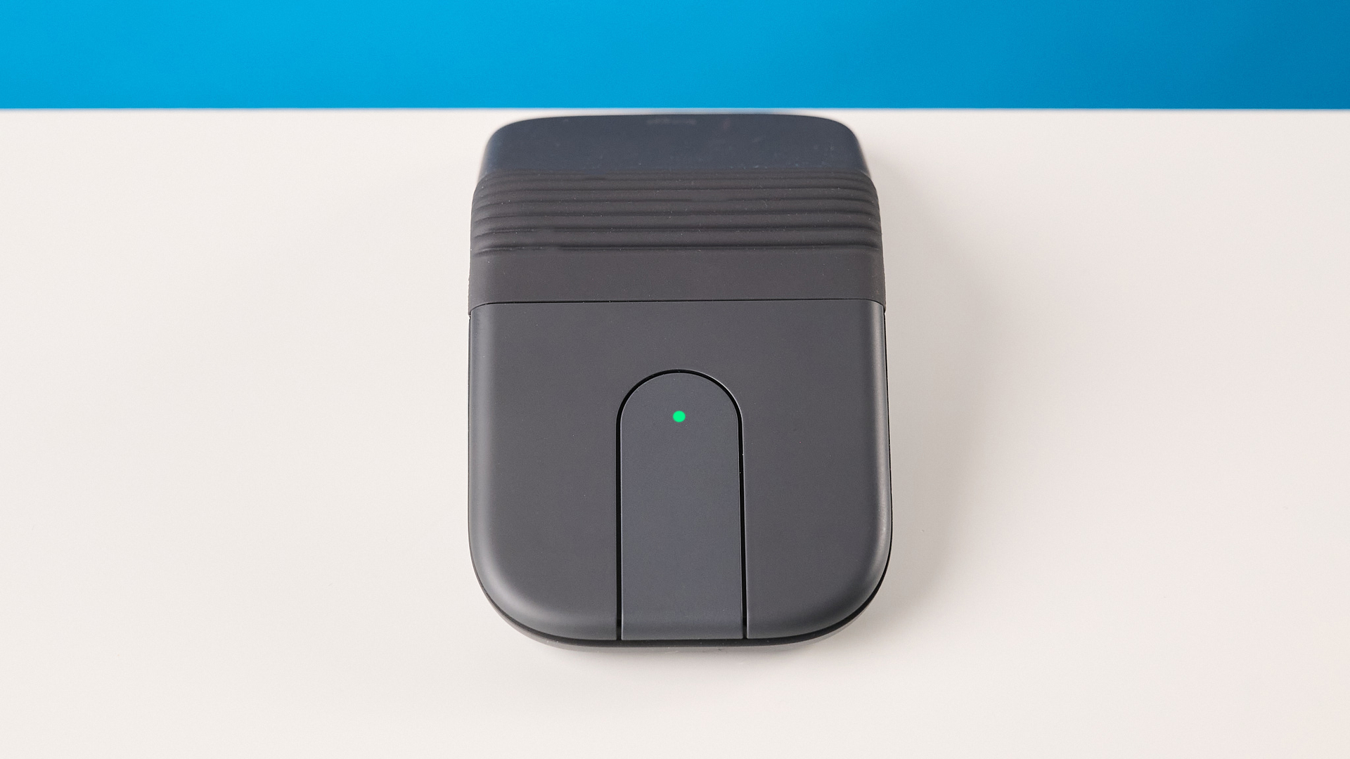 עכבר Logitech Mobi Fold בגרפיט מצולם מול רקע כחול