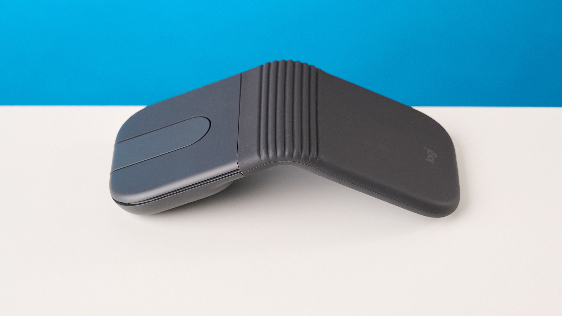 עכבר Logitech Mobi Fold בגרפיט מצולם מול רקע כחול