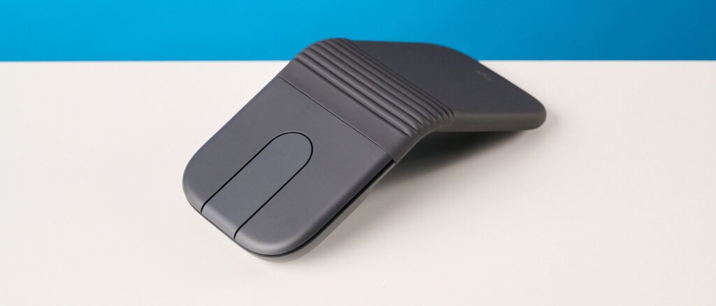 Logitech Mobi Fold mouse in graphite photographed in front of a blue background