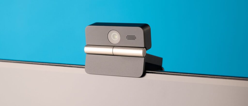 Obsbot Meet Flip foldable webcam photographed in front of a blue background