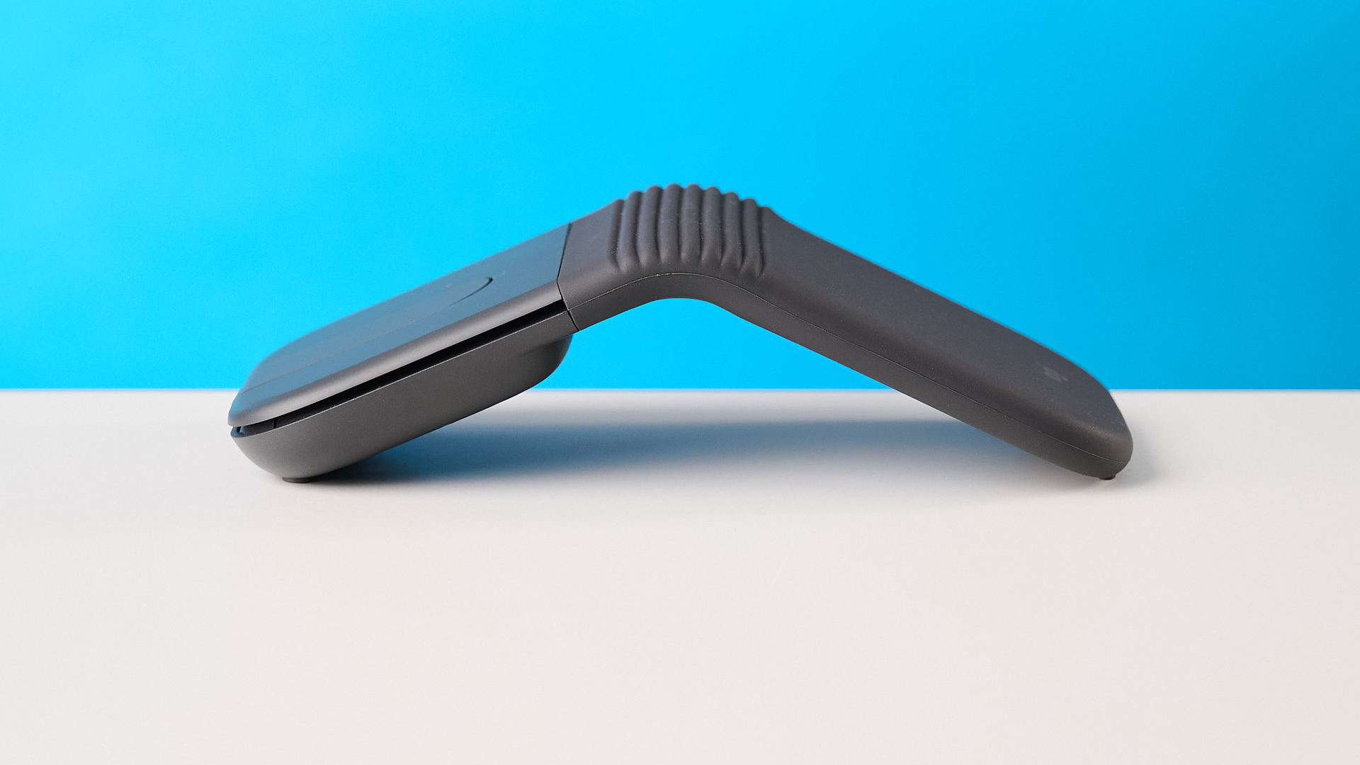 עכבר Logitech Mobi Fold בגרפיט מצולם מול רקע כחול