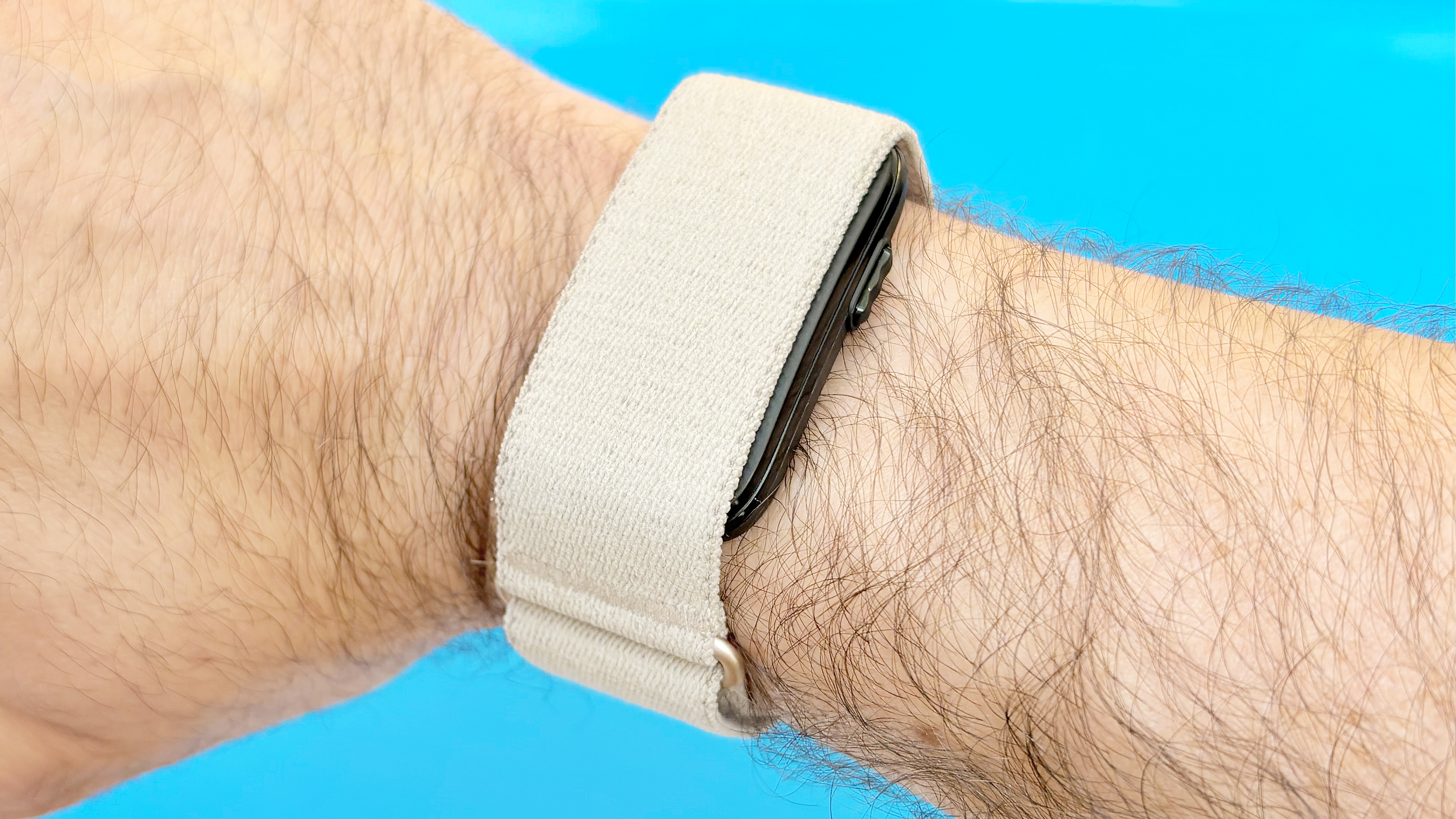 תקריב של Garmin Cirqa על פרק כף היד של המבקר על רקע כחול