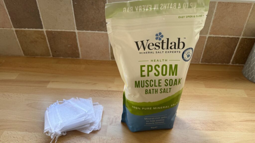 A bag of epsom salts and a pile of small net bags lay on a countertop