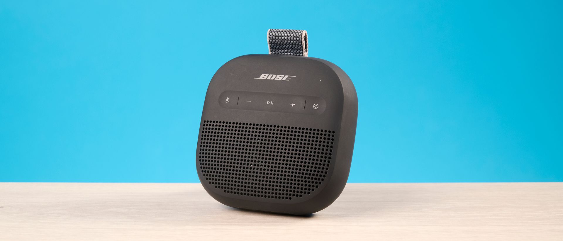 Bose SoundLink Micro 2 in black photographed in front of a blue background
