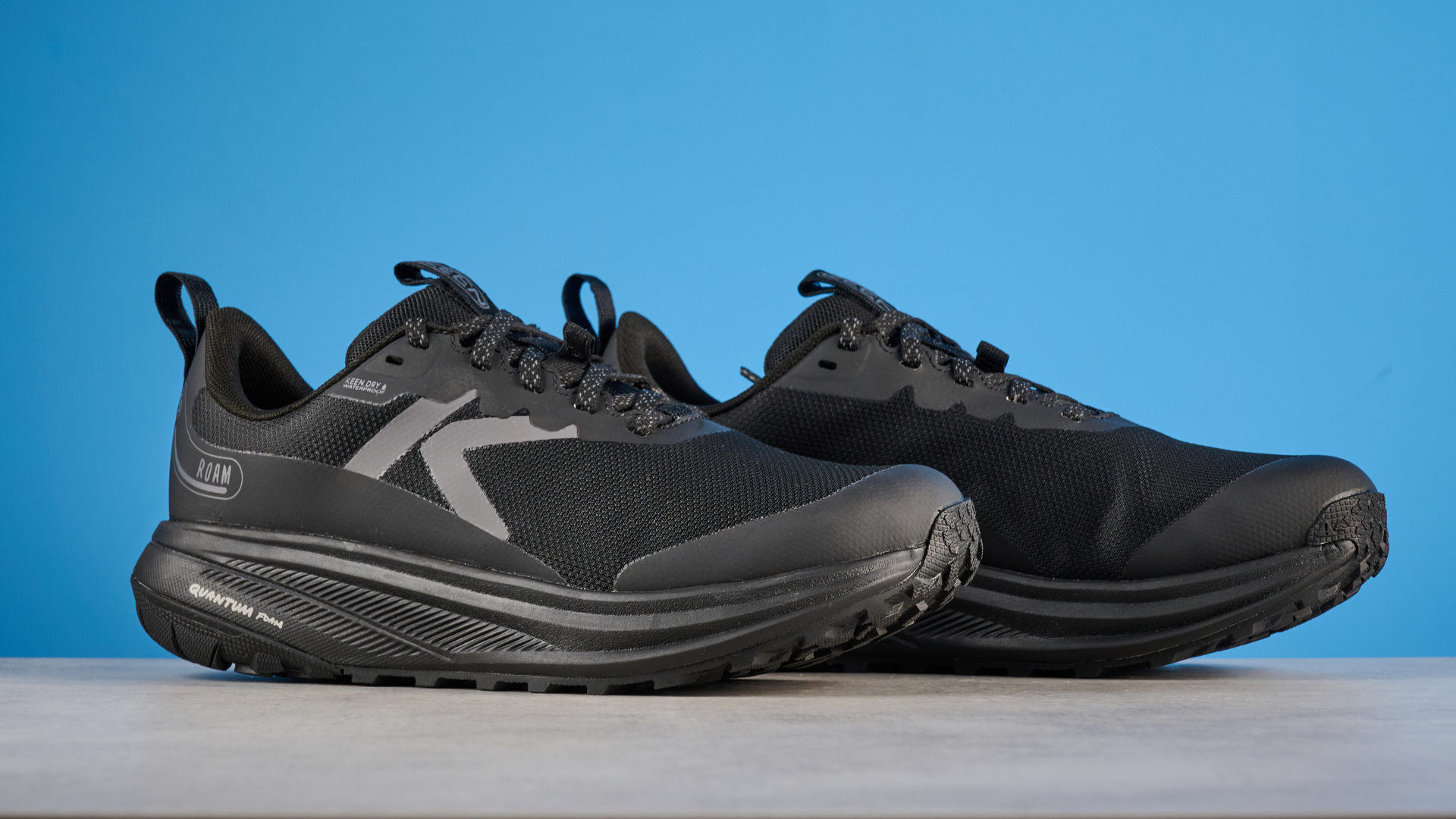 נעלי ריצה Keen Roam רכבת בשחור מצולמות מול רקע כחול