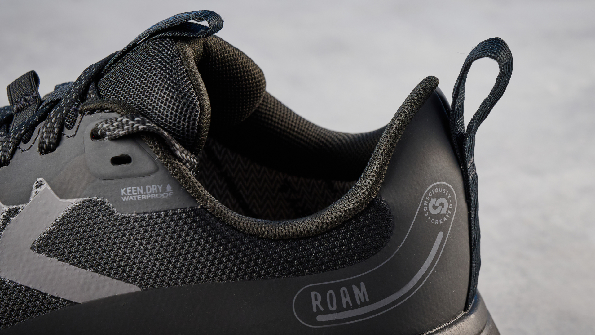 נעלי ריצה Keen Roam רכבת בשחור מצולמות מול רקע כחול