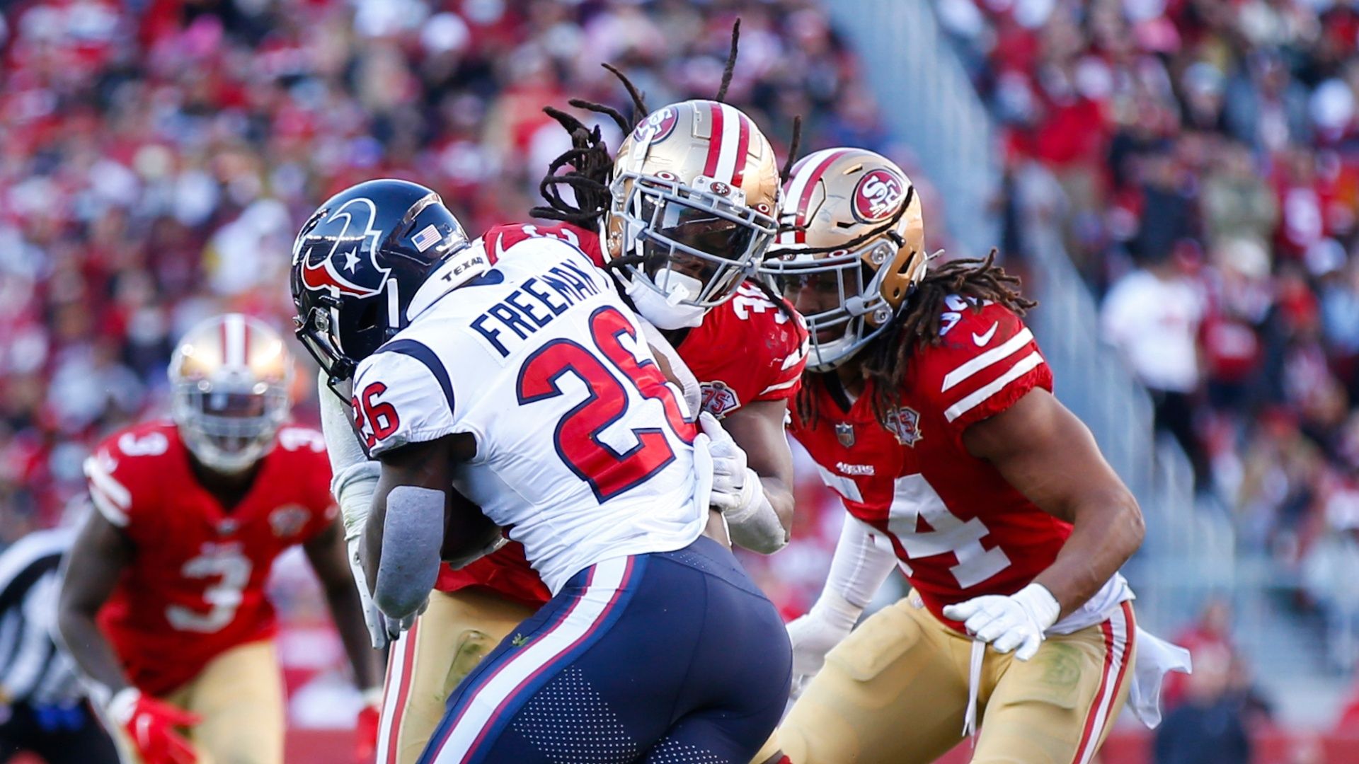 Marcell Harris and Fred Warner of the San Francisco 49ers tackle Royce Freeman of the Houston Texans during an NFL game on January 2, 2022