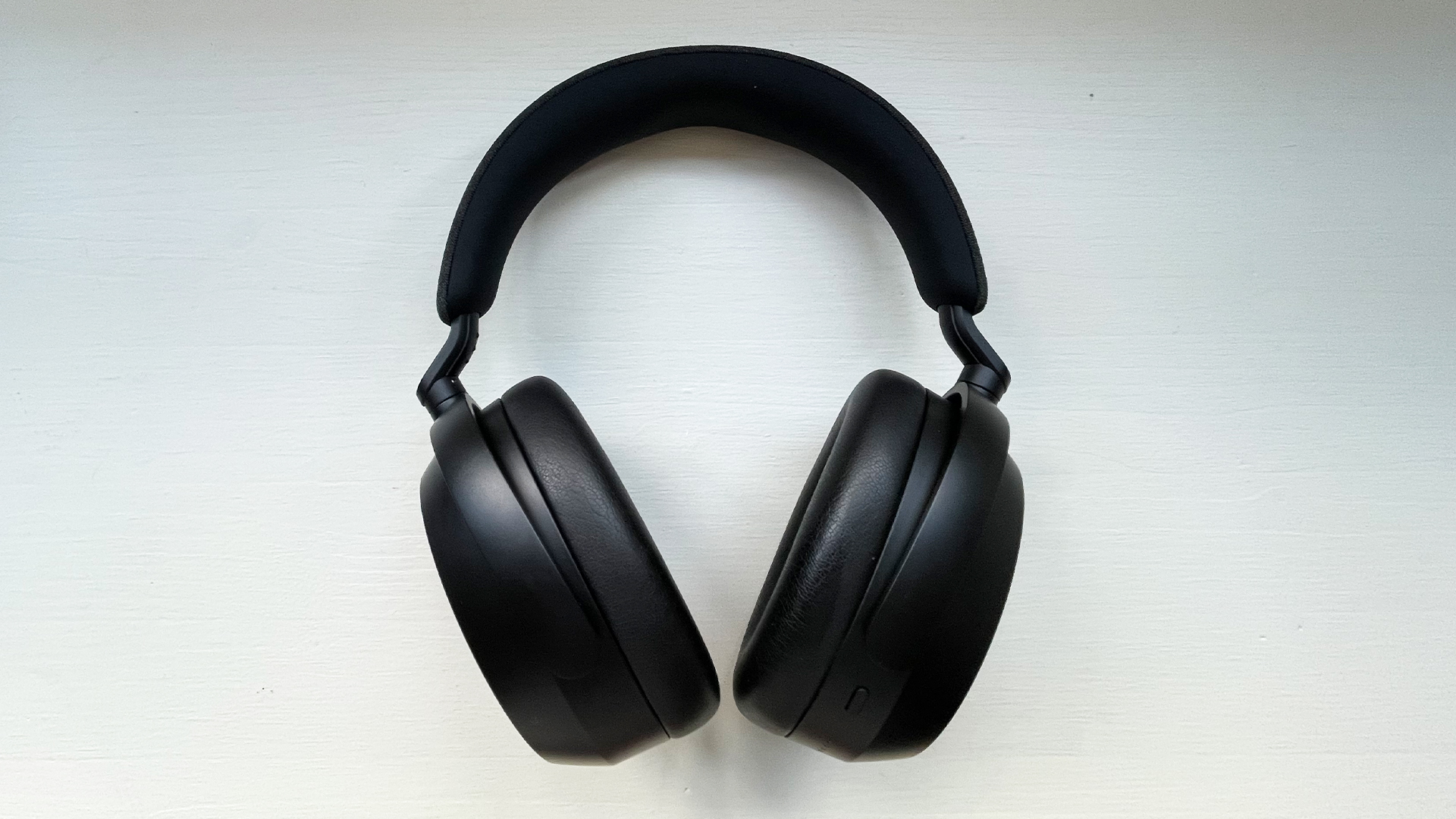 Sennheiser Momentum 4 Wireless בצבע שחור ממוקם בצדם על מושב חלון