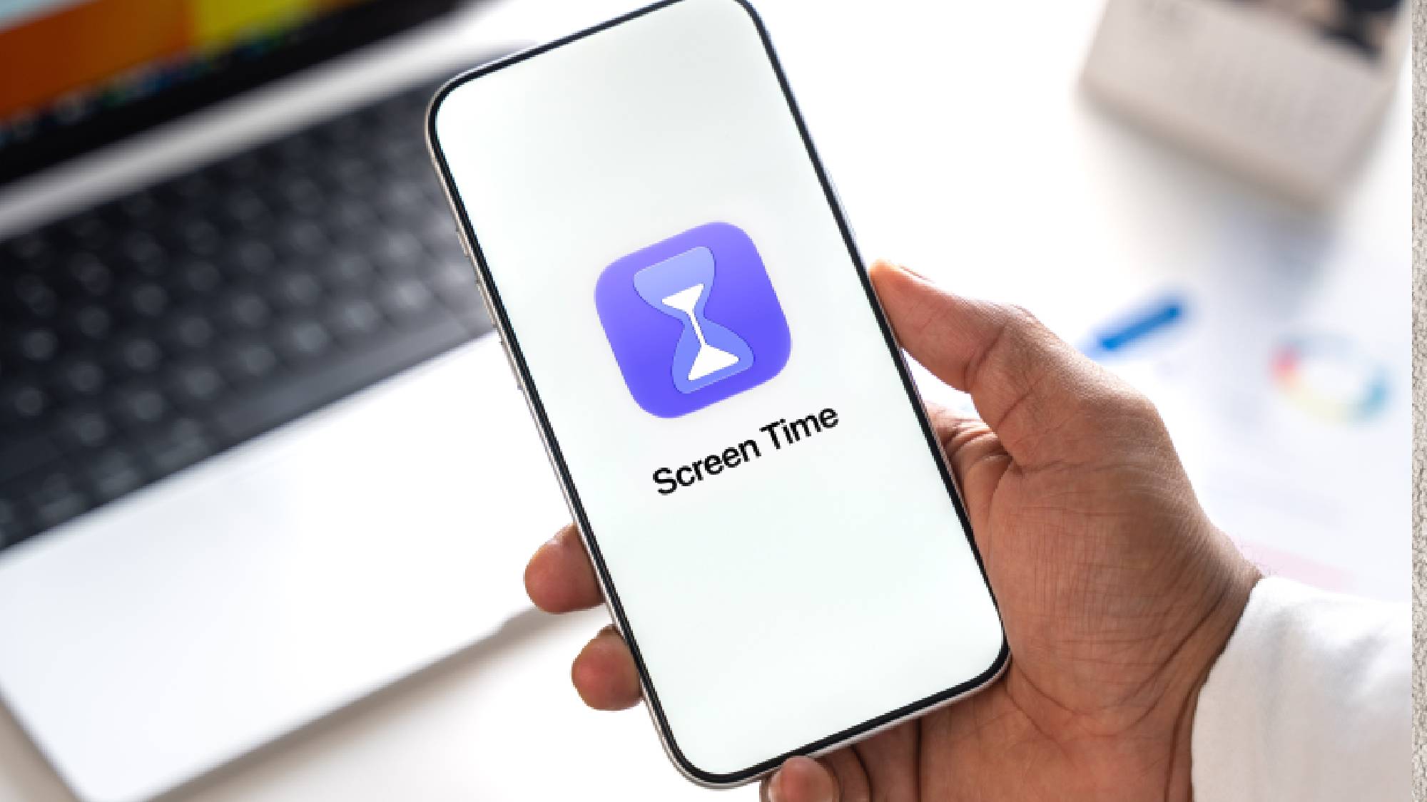 יד אוחזת באייפון המציג את סמל אפליקציית Apple Screen Time