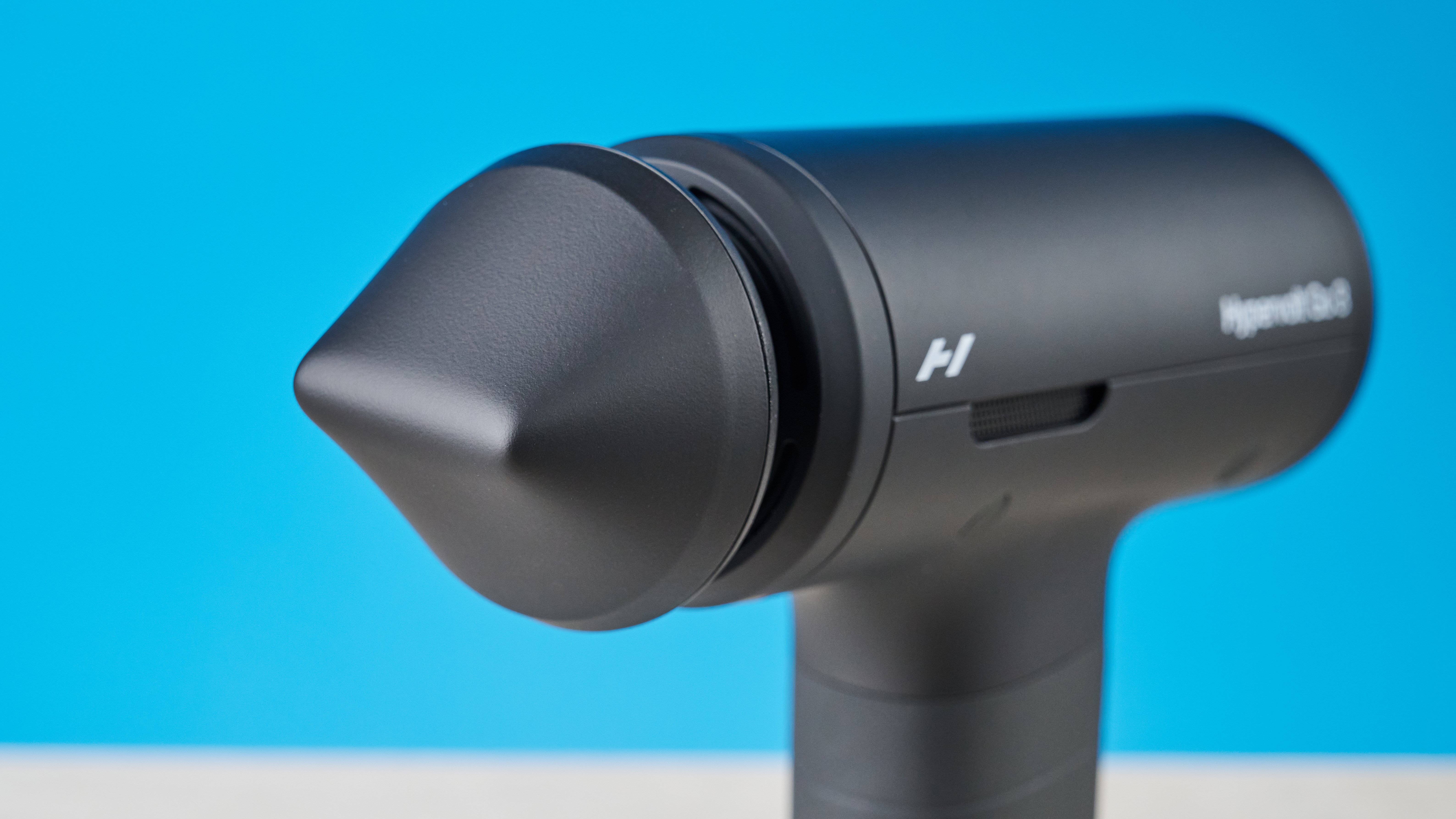 אקדח עיסוי Hyperice Hypervolt Go 3 מצולם מול רקע כחול