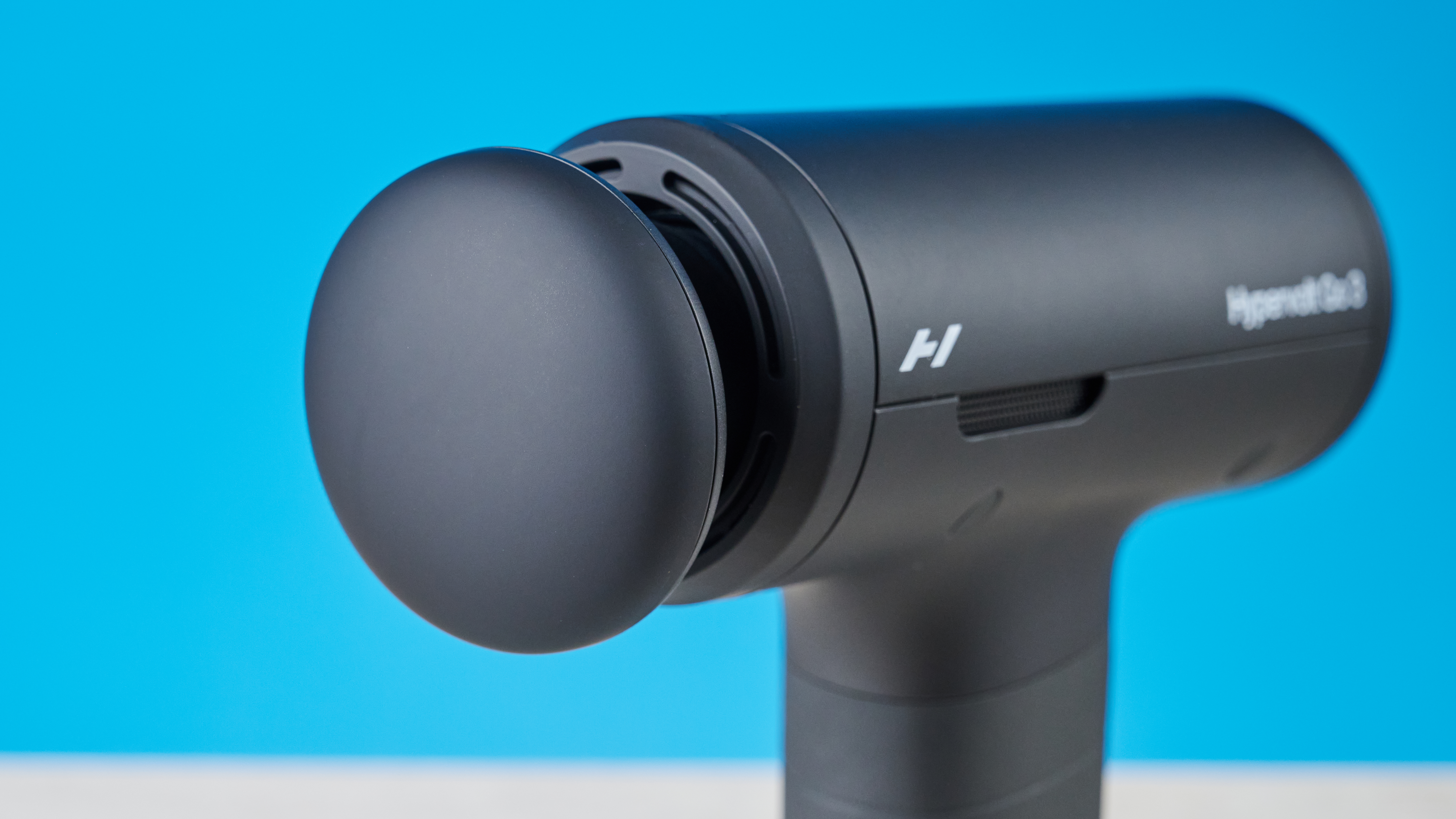 אקדח עיסוי Hyperice Hypervolt Go 3 מצולם מול רקע כחול