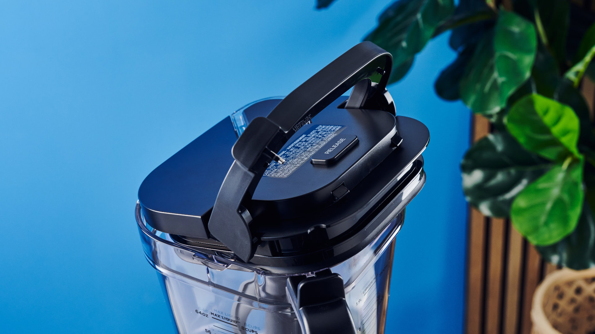 Ninja Crush Boss Blender בשחור מצולם מול רקע blee עם פירות.