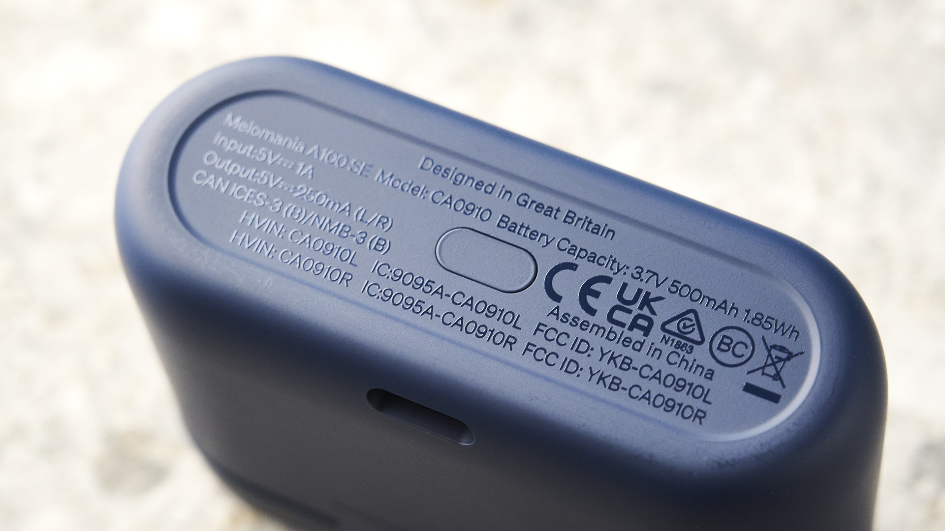 האוזניות של cambridge audio a100 se על רקע מדריך כחול עם שולחן בצבע אבן מתחת