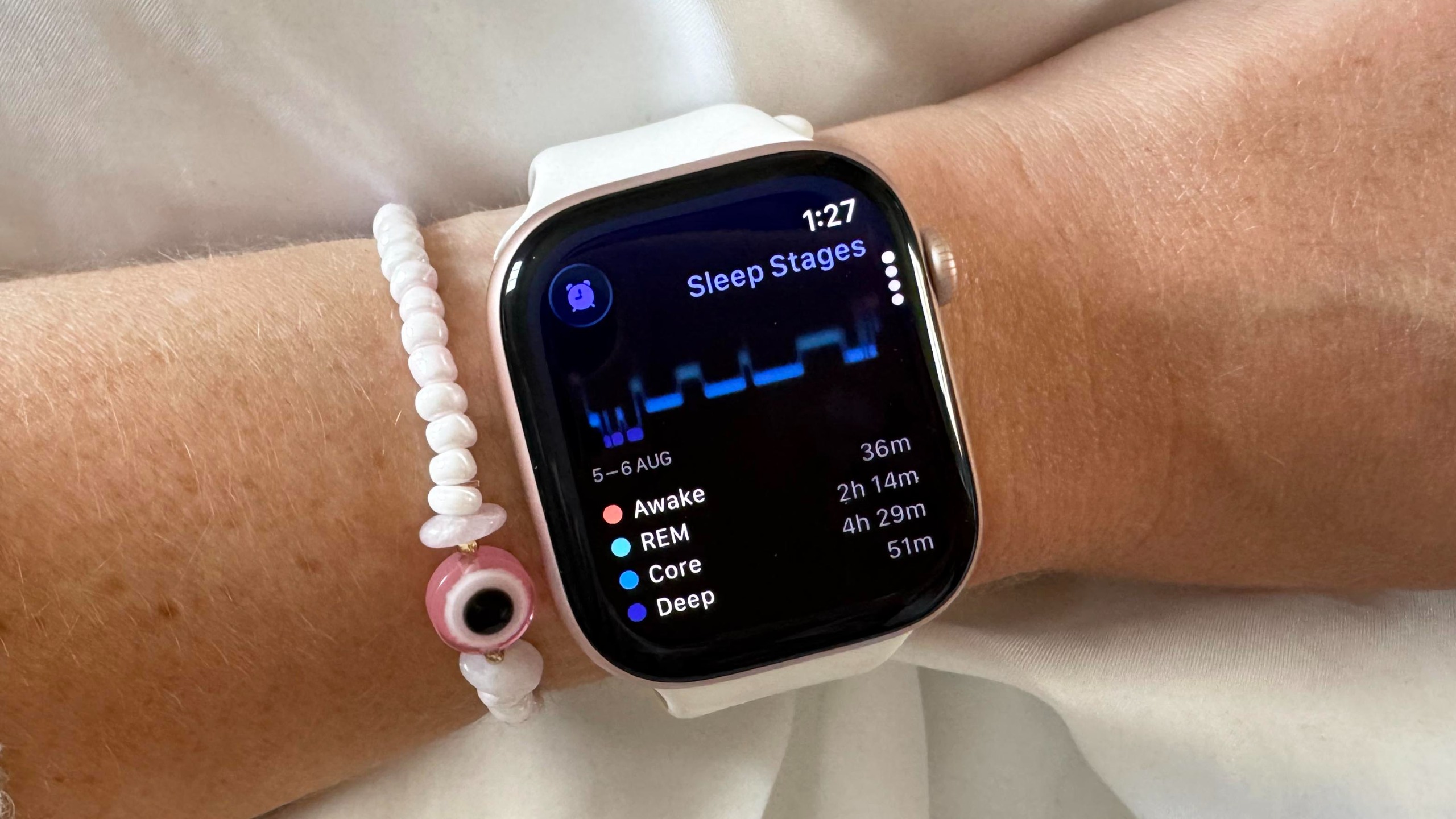 תקריב של ה-Apple Watch 12 על פרק כף היד של משתמש עם דוח שינה עדכני המוצג על המסך