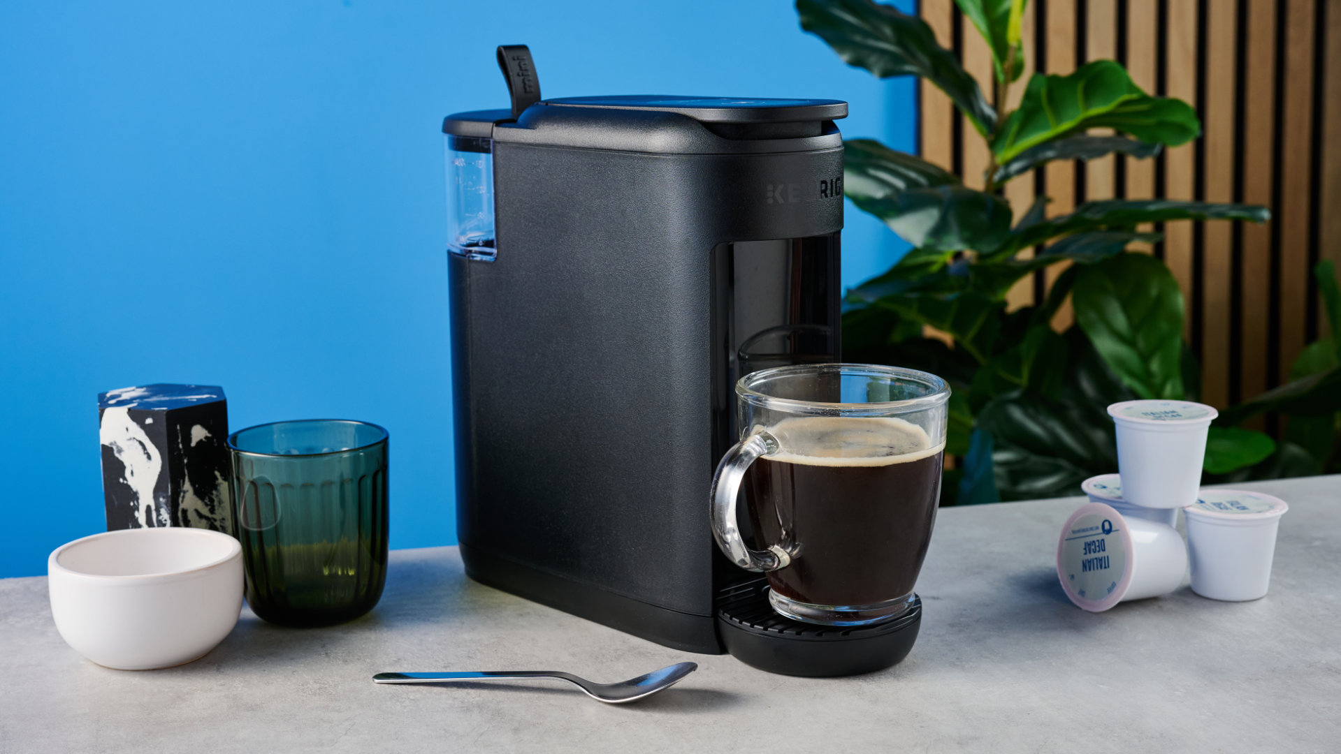 מכונת הקפה keurig k-mini mate שצולמה עם רקע המדריך הכחול