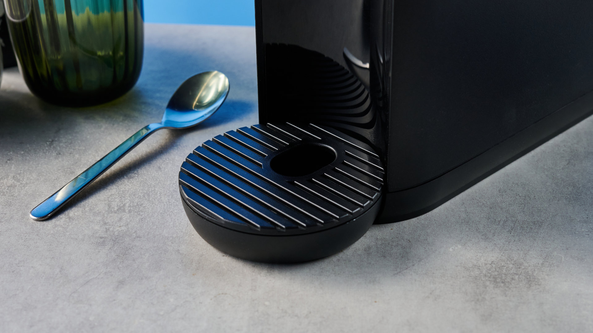 מכונת הקפה keurig k-mini mate שצולמה עם רקע המדריך הכחול