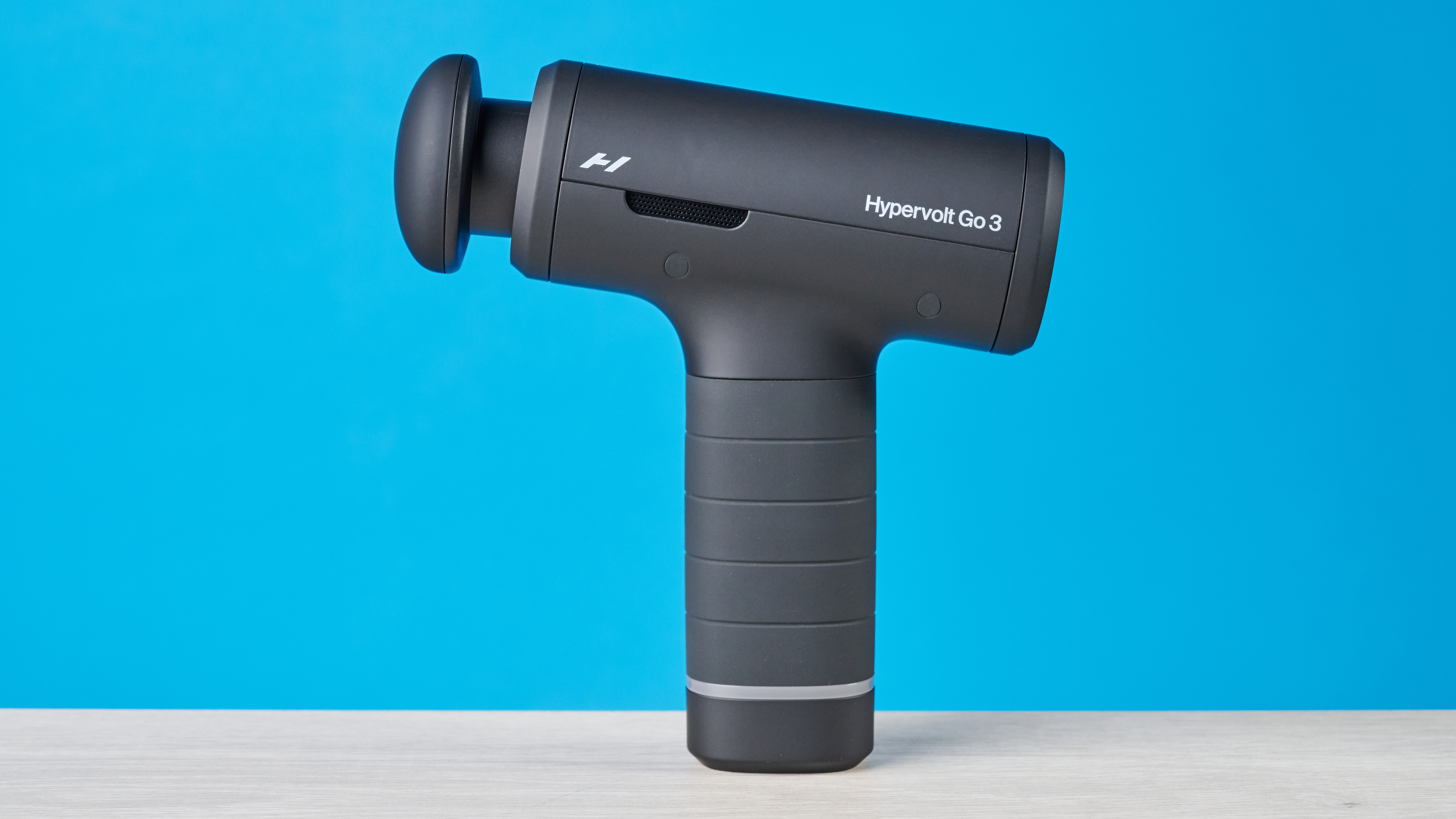 אקדח עיסוי Hyperice Hypervolt Go 3 מצולם מול רקע כחול