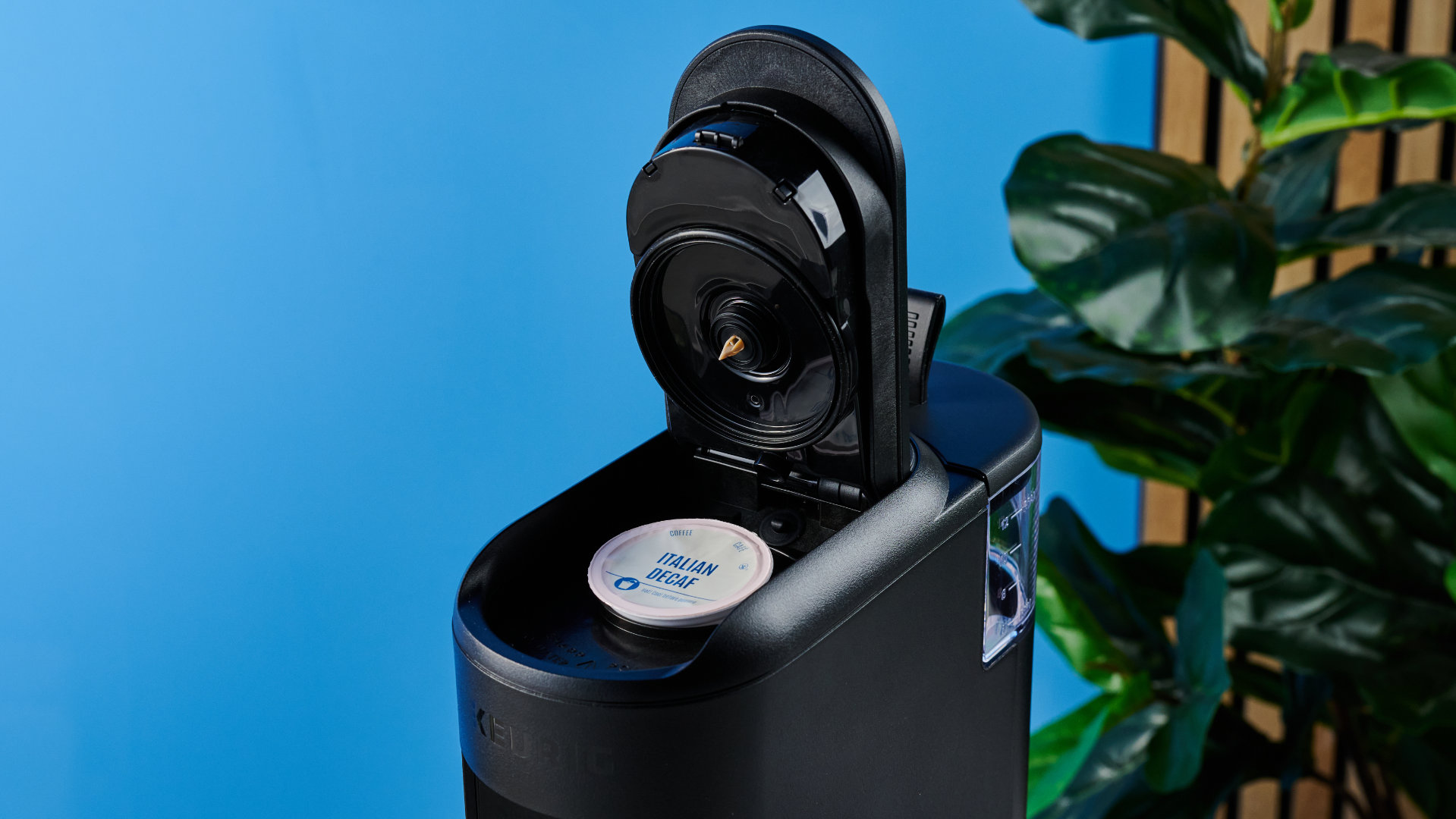 מכונת הקפה keurig k-mini mate שצולמה עם רקע המדריך הכחול