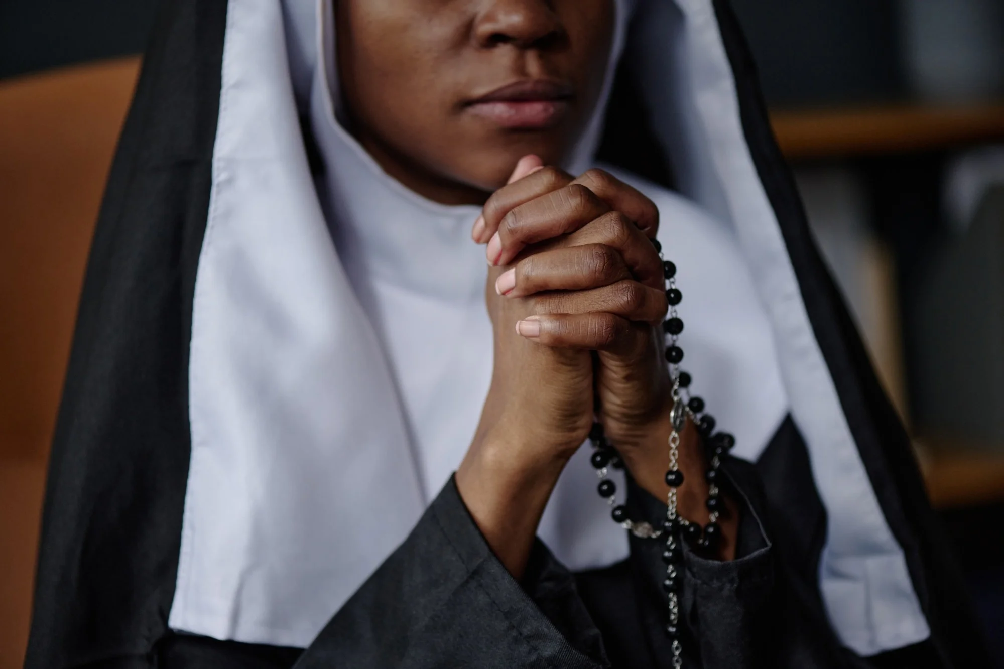 Nun praying with hands and rosary