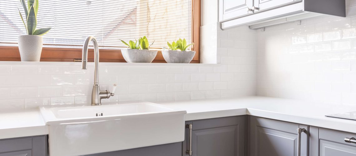 Sleek grey kitchen cabinetry with a white countertop