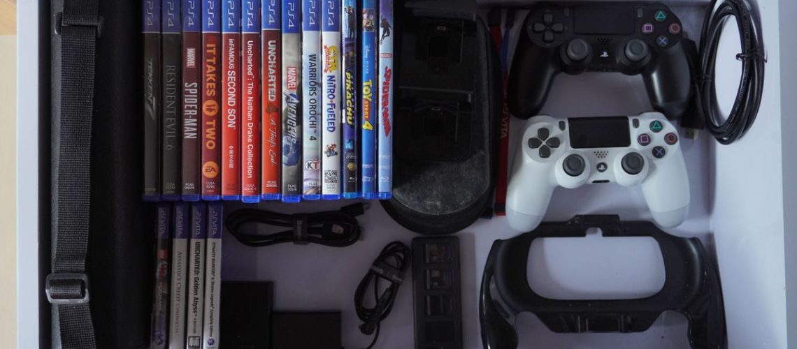 Video game collection in a drawer alongside a controller and wires packed neatly
