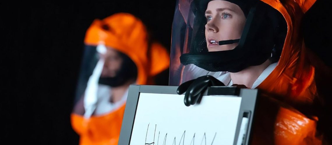 Amy Adams holds up a sign reading HUMAN in Arrival