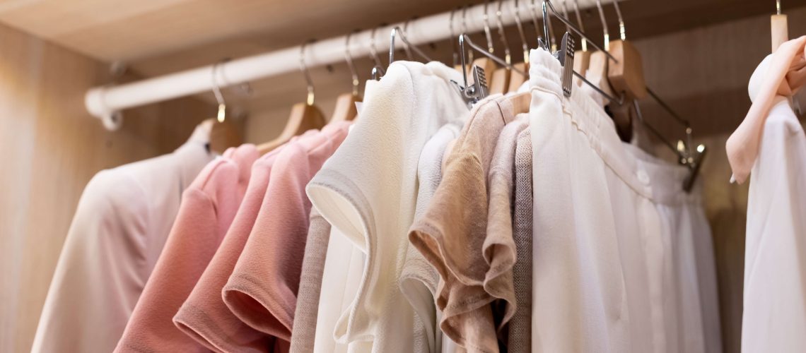 Clothing in neutral colours hanging on a clothes rail