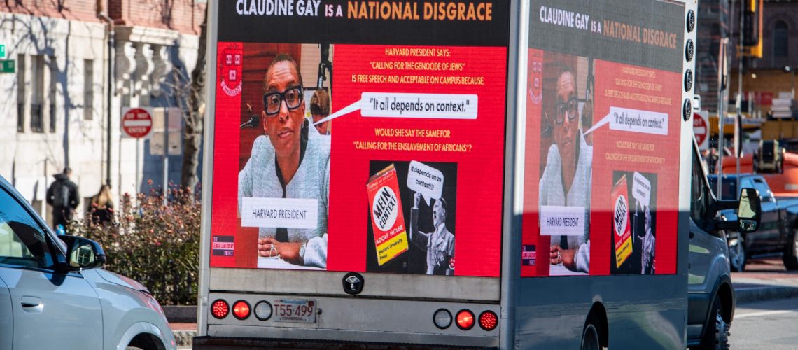 A truck reading "Claudine Gay is a National Disgrace," next to photos of Gay and Hitler, drives through Harvard's campus