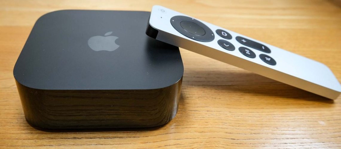 The Apple TV 4K (2022), with the Siri remote propped on its right side.