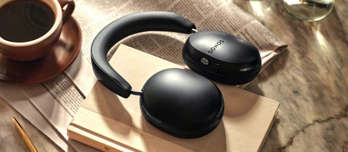Sonos Ace headphones in black with a coffee cup and newspaper
