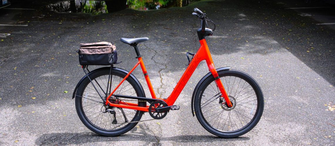 A red Trek Verve+ Lowstep LT bike against a dark asphalt background.