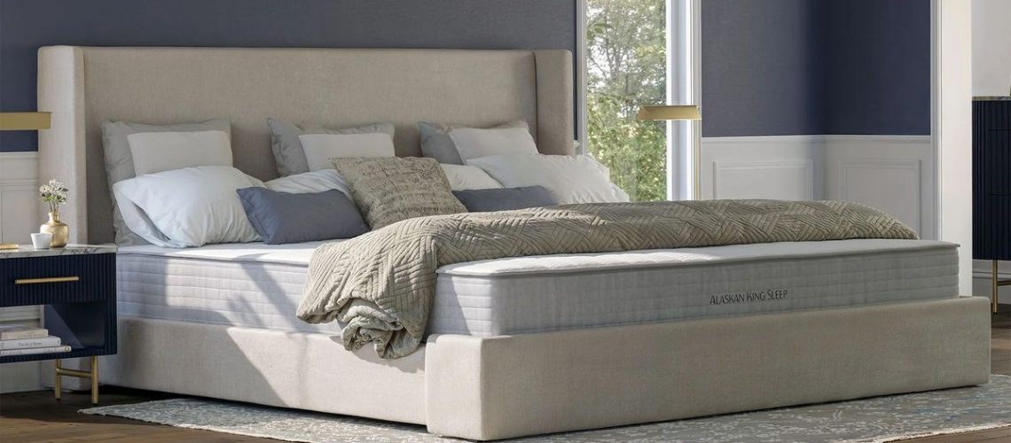 The Nolah Luxe Alaskan King Mattress in a large bedroom, with four pillows showing just how bug the mattress is