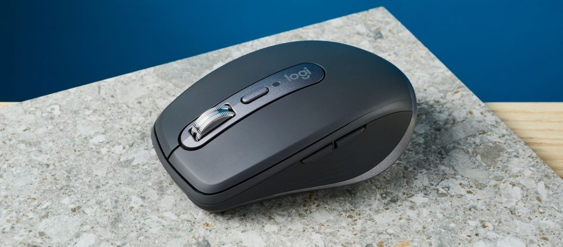 A photo of the Logitech MX Anywhere 3S mouse on a stone surface with a blue wall in the background.