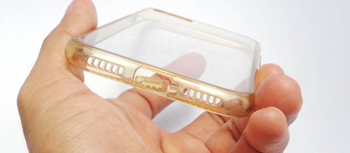 A clear phone case in a hand which has started to yellow