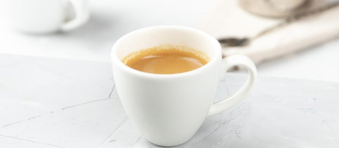 A cup of espresso on a stone worktop representing how to make espresso
