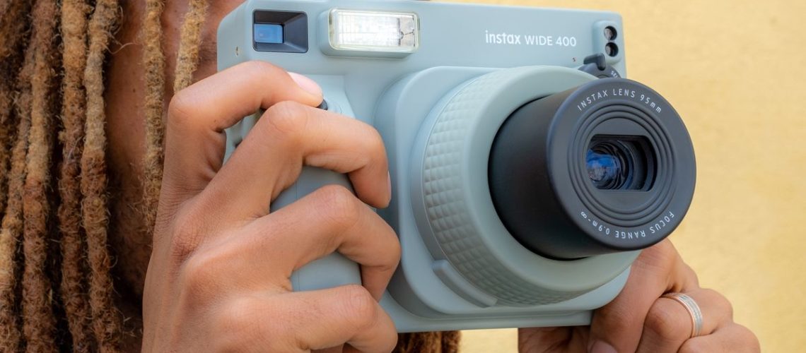 A person holding the Fujifilm Instax Wide 400 instant camera