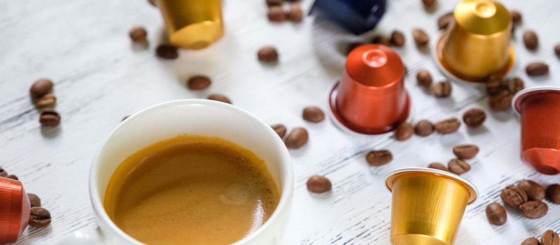 Cup of coffee with coffee pods and beans