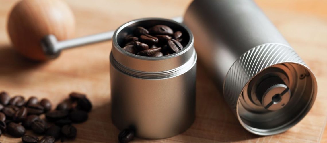 A handheld coffee grinder with coffee beans inside