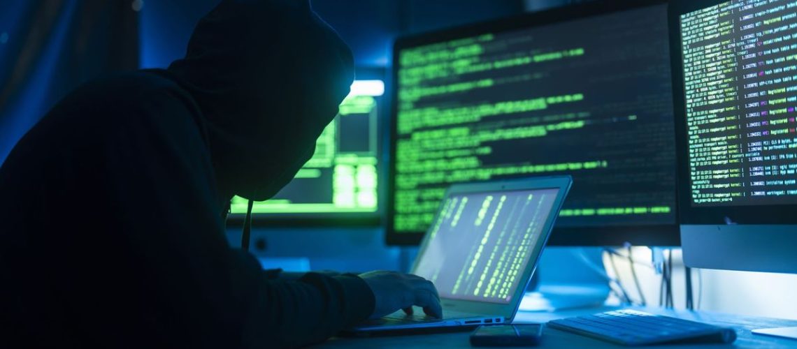 A stock image of a hacker using a computer to infect a server with a virus