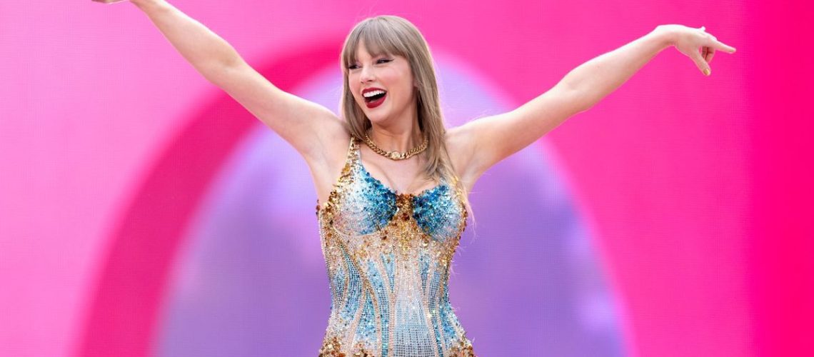 Taylor Swift onstage at Wembley Stadium on June 21st, 2024. She is wearing a sparkly gold and blue bodysuit