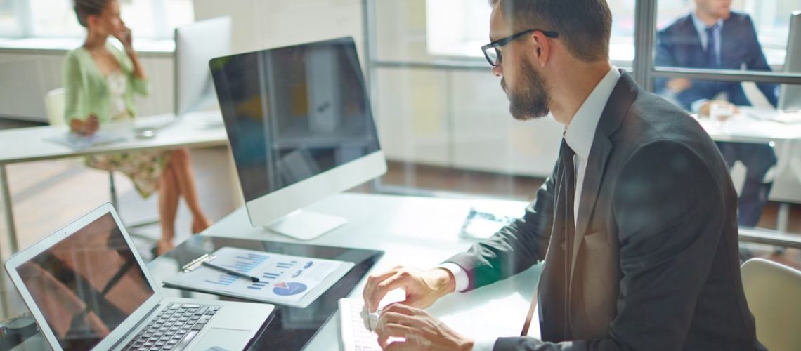 man sat at desk working on computer