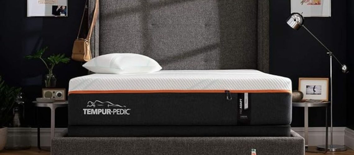 The Tempur-Pedic Tempur-ProAdapt mattress on a gray bed frame against a dark gray wall