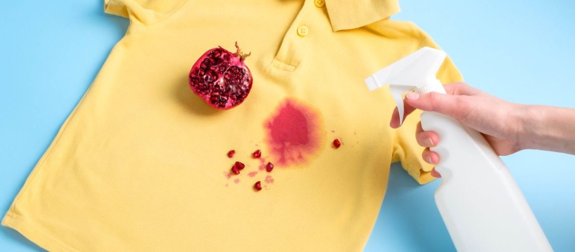 Spraying pomegranate stain on yellow t shirt