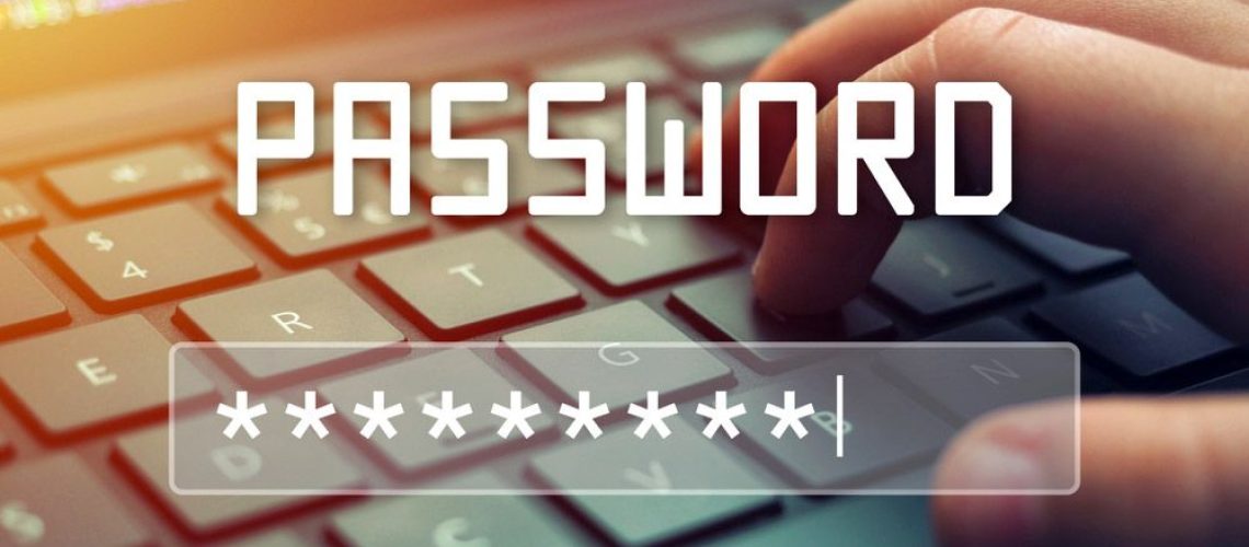 A hand types on a laptop keyboard while the word PASSWORD and a login field are superimposed.